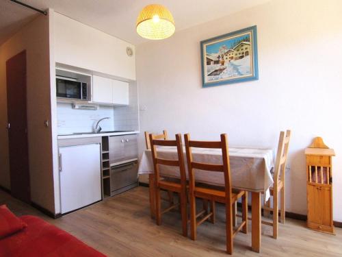 une cuisine et une salle à manger avec une table et des chaises dans l'établissement Studio confortable pour 4 personnes à L'Alpe d'Huez avec balcon, proche commerces et pistes - FR-1-405-32, à L'Alpe-d'Huez