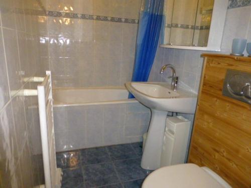 a bathroom with a sink and a toilet and a tub at Appartement Huez, 1 pièce, 4 personnes - FR-1-405-45 in L'Alpe-d'Huez