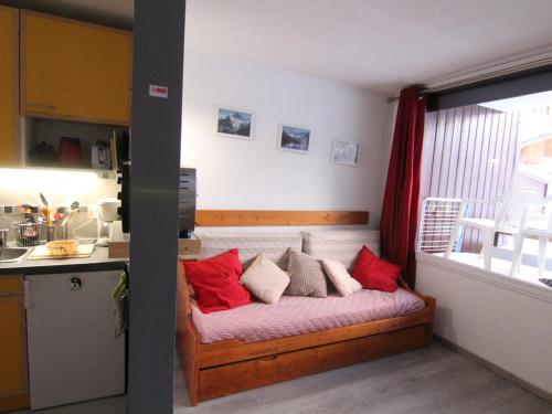 - un lit dans une cuisine avec des oreillers rouges dans l'établissement Studio cosy pour 5 pers. à 100m des pistes - Balcon sud, animaux acceptés, près commerces - Alpe d'Huez - FR-1-405-64, à L'Alpe-d'Huez