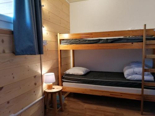 une chambre avec deux lits superposés et une lampe dans l'établissement Appartement 2 pièces 6 pers avec balcon, parking et animaux acceptés - L'Alpe d'Huez - FR-1-405-10, à L'Alpe-d'Huez