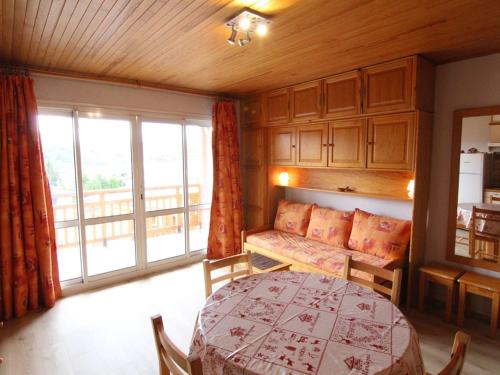 un salon avec une table et un canapé dans l'établissement Studio 4 pers, 28m², Alpe d'Huez - Proche pistes et commerces, balcon sud, casier à skis - FR-1-405-30, à L'Alpe-d'Huez