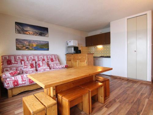 une cuisine avec une table en bois et un canapé dans l'établissement Appartement cosy 2 pièces, 6 pers, balcon sud, proche pistes et commerces - Alpe d'Huez - FR-1-405-46, à L'Alpe-d'Huez