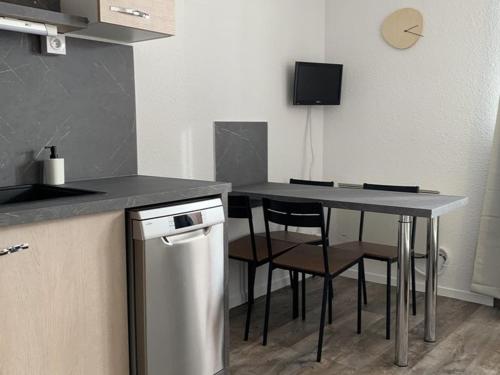 une cuisine avec un comptoir, une table et des chaises dans l'établissement Appartement cosy 4 pers. avec balcon sud, proche commerces et remontées, L'Alpe d'Huez - FR-1-405-61, à L'Alpe-d'Huez