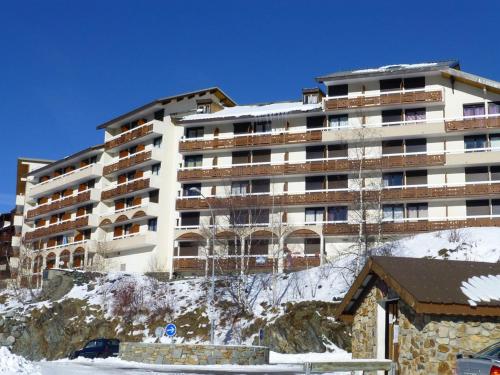 un grand bâtiment au sommet d'une montagne enneigée dans l'établissement Appartement cosy 4 pers. avec balcon sud, proche commerces et remontées, L'Alpe d'Huez - FR-1-405-61, à L'Alpe-d'Huez