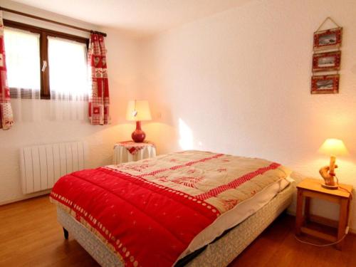 une chambre avec un lit avec une couverture rouge dessus dans l'établissement Appartement cosy au cœur de l'Alpe d'Huez - 6 pers, 38m², balcon sud, skis à 240m - FR-1-405-79, à L'Alpe-d'Huez