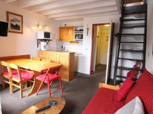 une cuisine et une salle à manger avec une table et des chaises dans l'établissement Charmant duplex 6 pers avec mezzanine, espace bébé, proche commerces et remontées à l'Alpe d'Huez - FR-1-405-89, à L'Alpe-d'Huez