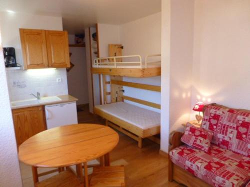 Cette petite chambre comprend des lits superposés et une table. dans l'établissement Studio cosy pour 4 à L'Alpe d'Huez - Emplacement idéal, animaux acceptés, proche pistes et commerces - FR-1-405-96, à L'Alpe-d'Huez