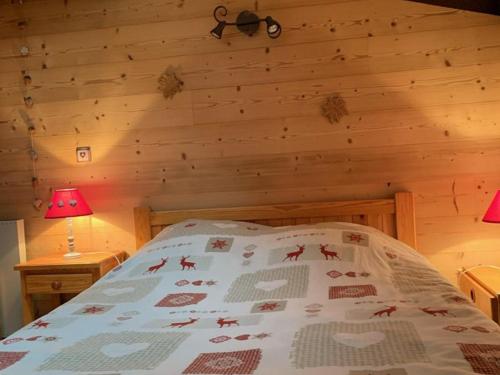 une chambre avec un lit dans une cabane en rondins dans l'établissement Charmant 2 pièces avec mezzanine, balcon, et accès direct aux pistes - Vieil Alpe - FR-1-405-80, à L'Alpe-d'Huez