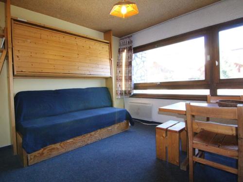 a bedroom with a bed and a table and window at Appartement Huez, 1 pièce, 2 personnes - FR-1-405-91 in L'Alpe-d'Huez