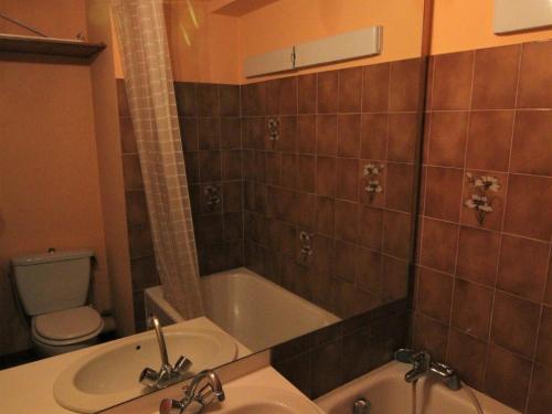 a bathroom with a sink and a tub and a toilet at Appartement Huez, 1 pièce, 2 personnes - FR-1-405-91 in L'Alpe-d'Huez