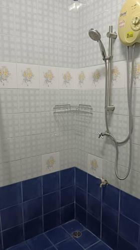 a bathroom with a shower with a blue tile wall at Naka Tangerine Holiday Home by Bcare in Ban Rangeng