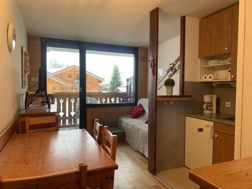 a kitchen and living room with a view of a balcony at Appartement Huez, 2 pièces, 4 personnes - FR-1-405-112 in L'Alpe-d'Huez