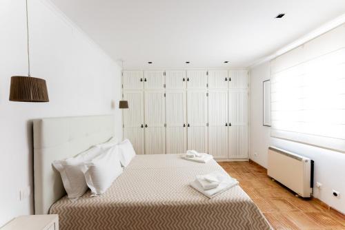 a white bedroom with a bed and a window at Courela da Lameira in Reguengos de Monsaraz