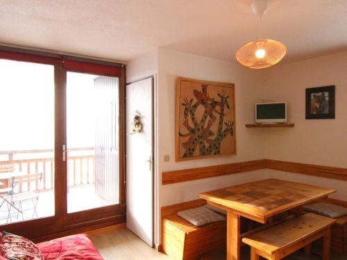 d'un salon avec une table et un balcon. dans l'établissement Appartement cosy 2 pièces, balcon sud, proche remontées et commerces, parking, casier à skis, 5 pers - FR-1-405-107, à L'Alpe-d'Huez