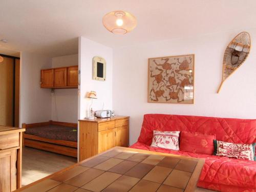 un salon avec un canapé rouge et une table dans l'établissement Appartement cosy 2 pièces, balcon sud, proche remontées et commerces, parking, casier à skis, 5 pers - FR-1-405-107, à L'Alpe-d'Huez