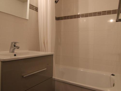 une salle de bain avec un lavabo et une baignoire dans l'établissement Appartement cosy 2 pièces, balcon sud, proche remontées et commerces, parking, casier à skis, 5 pers - FR-1-405-107, à L'Alpe-d'Huez