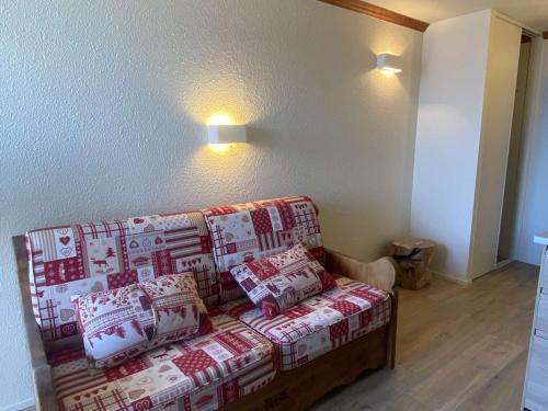 - un salon avec un canapé et des oreillers rouges et blancs dans l'établissement Appartement 4 pers, balcon sud, quartier Passeaux - Alpe d'Huez - FR-1-405-111, à L'Alpe-d'Huez