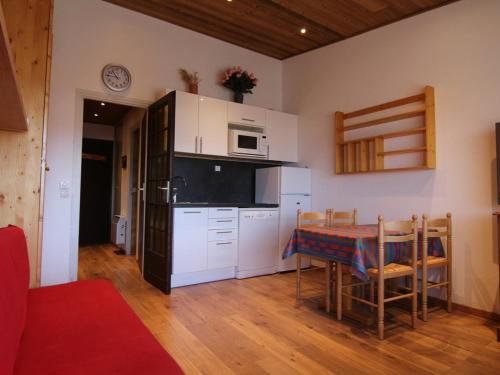 une cuisine avec une table et un four micro-ondes ainsi qu'une cuisine avec une table et des chaises dans l'établissement Studio cosy pour 4 à L'Alpe d'Huez, proche pistes et commerces, balcon sud, casier à skis. - FR-1-405-117, à L'Alpe-d'Huez