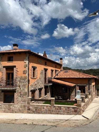 a large brick building on the side of a street at La Traviesa de la Demanda in Cabezón de la Sierra