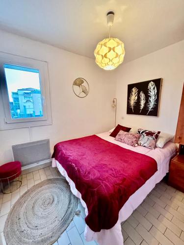 une chambre avec un grand lit avec une couverture rouge dans l'établissement T2 VUE PANORAMIQUE SUR MER QUARTIER DES QUILLES, à Sète