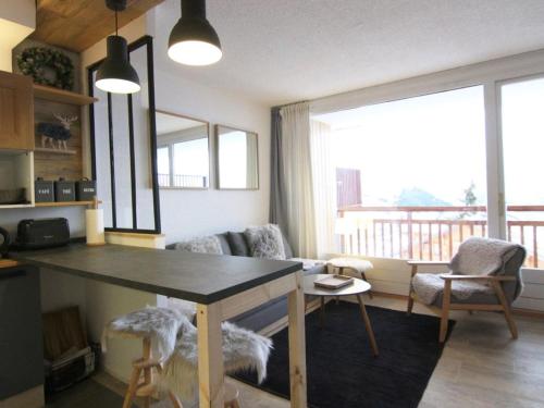 Il dispose d'une cuisine et d'un salon avec une table et un balcon. dans l'établissement Charmant studio 4 pers avec balcon, parking et accès pistes - Alpe d'Huez - FR-1-405-134, à L'Alpe-d'Huez