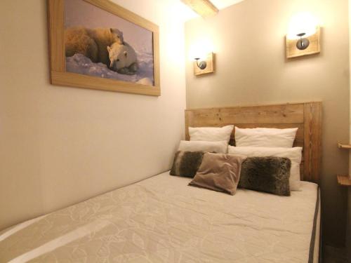 une chambre avec un lit avec un tableau sur le mur dans l'établissement Charmant studio 4 pers avec balcon, parking et accès pistes - Alpe d'Huez - FR-1-405-134, à L'Alpe-d'Huez