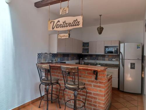eine Küche mit einer Backsteintheke und einem Kühlschrank in der Unterkunft Casa Carambolo in Cali