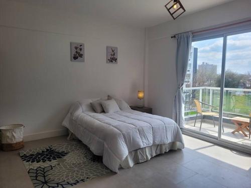 Dormitorio blanco con cama y ventana grande en Studio con vista al parque. en Canning