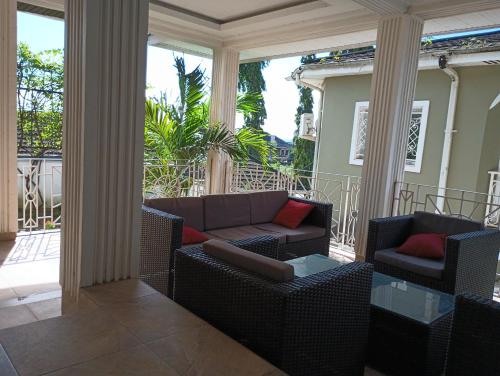 a porch with chairs and a couch and a table at Himma's Apartments in Adonkia