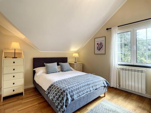 a bedroom with a bed and a window at Vinhaticos Villa by Atlantic Holiday in Porto Moniz