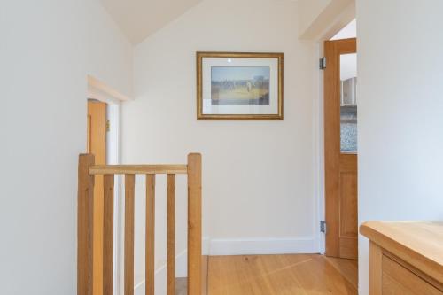 a stairway with a picture on the wall at 138 North Street - luxury 2 bed 2 bath with secret garden, summerhouse, putting green in St Andrews