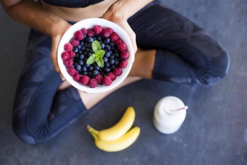 a person holding a bowl of berries and bananas at Longevity Health & Wellness Hotel - Adults Only in Alvor