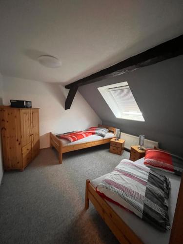 a attic bedroom with two beds and a skylight at Pension 1 Ferienhof Hanstorf in Satow