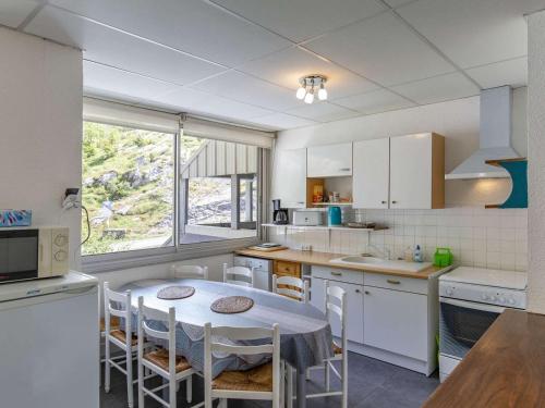 une cuisine avec une table et quelques chaises dans l'établissement Appartement 8 places à Gourette, 3 chambres, proche pistes - FR-1-400-50, à Gourette