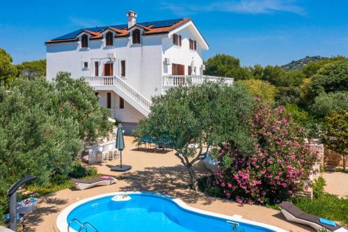 a villa with a swimming pool in front of a house at Luxury Villa Bella Vista with Swimming Pool in Betina