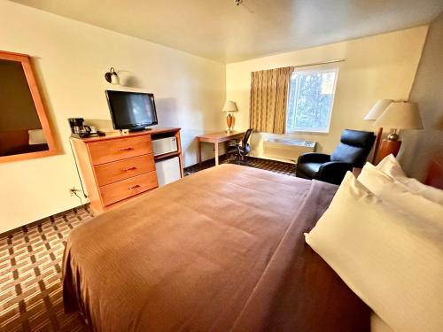 a hotel room with a large bed and a television at FairBridge Inn & Suites Kellogg in Kellogg