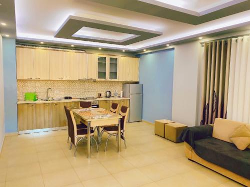een keuken en een woonkamer met een tafel en een bank bij Chloe Apartament in Berat