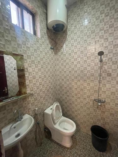 a bathroom with a toilet and a sink at Furaha Suite Apartment in Mwanakwerekwe