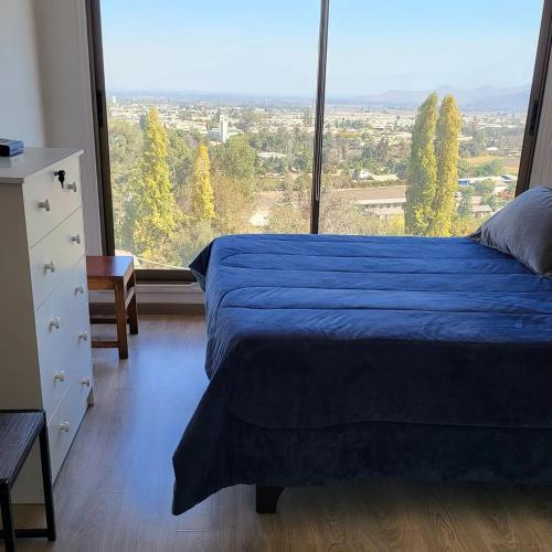 ein Schlafzimmer mit einem blauen Bett und einem großen Fenster in der Unterkunft Hostal Casa Pettra in Colina
