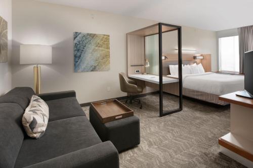 Habitación de hotel con sofá y cama en SpringHill Suites by Marriott San Angelo, en San Angelo