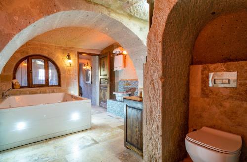 a bathroom with a bath tub and a toilet at CAPPANAR CAVE HOTEL in Nar
