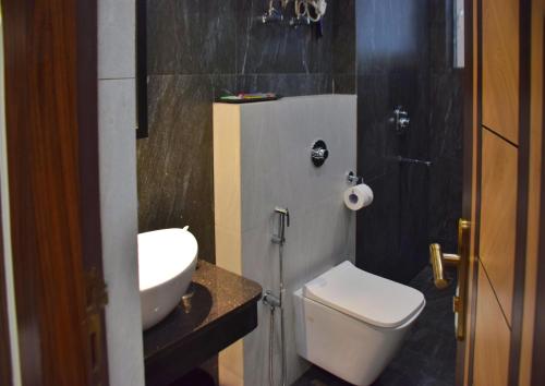 La salle de bains est pourvue de toilettes blanches et d'un lavabo. dans l'établissement GOLDEN GLEAM RESORTS, à Ingrāj Bāzār