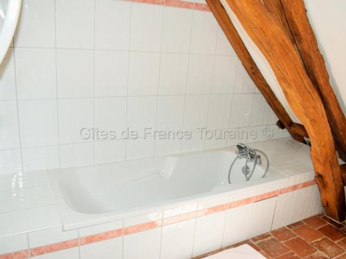 eine Badewanne im Bad mit einem Schild an der Wand in der Unterkunft Gîte Paulmy, 4 pièces, 7 personnes - FR-1-381-321 in Paulmy
