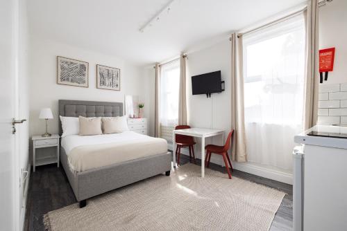 a bedroom with a bed and a table and a desk at Euston apartments in London