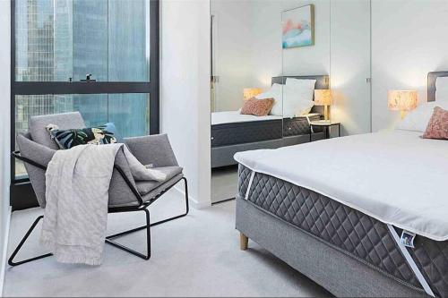 um quarto com uma cama, uma cadeira e uma janela em Modern 1 BR Apt on Southbank #Australia108#AU2117 em Melbourne