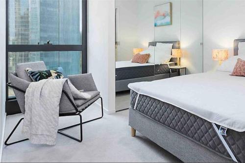 a bedroom with a bed and a chair and a window at Modern 1 BR Apt on Southbank #Australia108#AU21 in Melbourne