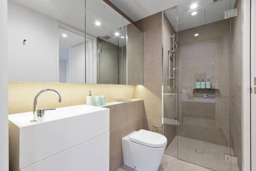 uma casa de banho com um chuveiro, um WC e um lavatório. em Modern 1 BR Apt on Southbank #Australia108#AU2117 em Melbourne