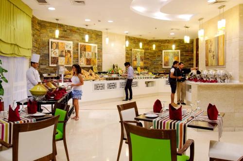 a restaurant with people preparing food in a kitchen at Swiss Inn Teda Hotel & Aqua Park in Ain Sokhna