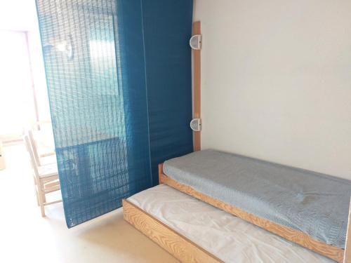 une chambre avec un lit et un mur bleu dans l'établissement Studio 4 pers, skis aux pieds, proche commerces, animaux acceptés - Les Arcs 1800 - FR-1-411-492, à Arc 1800