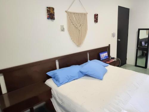 a bedroom with a bed with two blue pillows at On The Beach - Seaside Sunrise Haven 3 Bedrooms SEA VIEW in Cancún